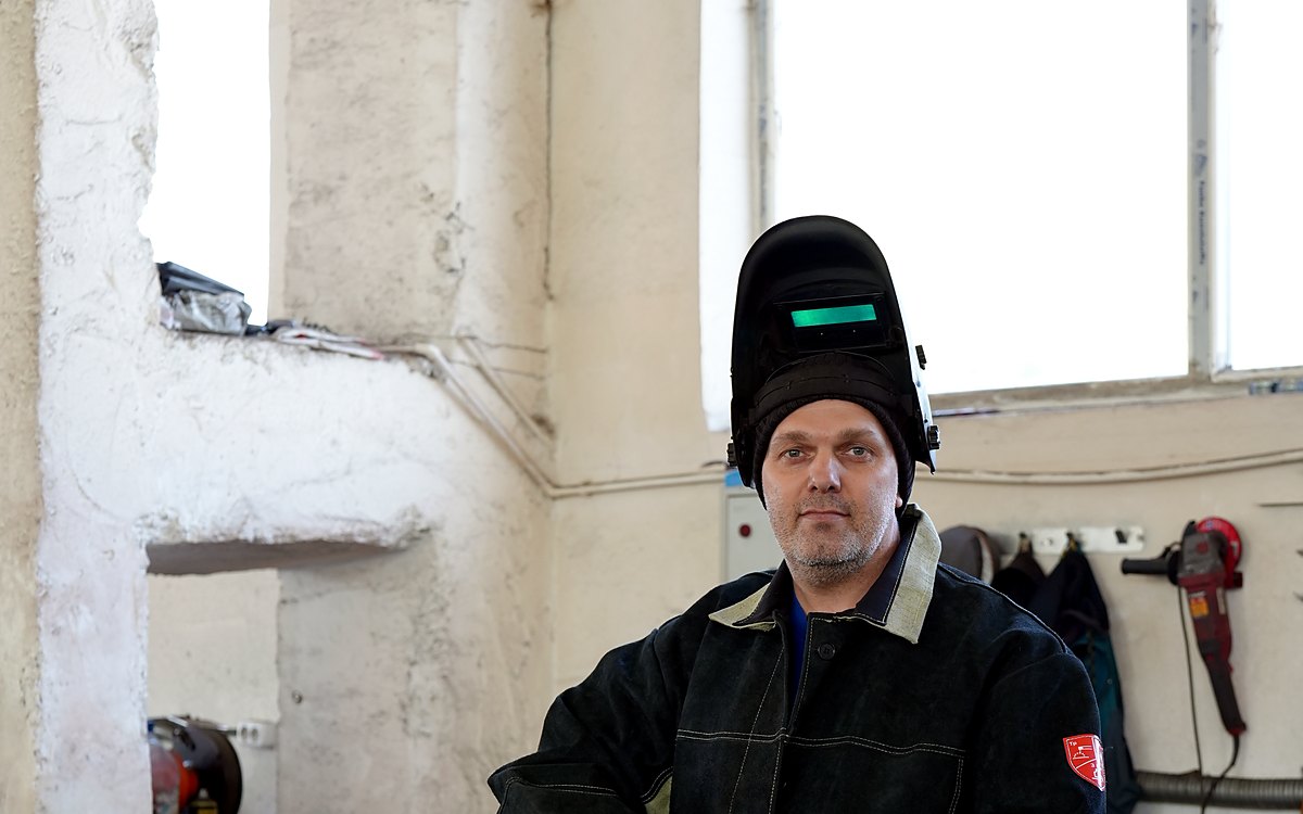KZTM welder in a protective mask at a MIG welding machine, Karaganda
